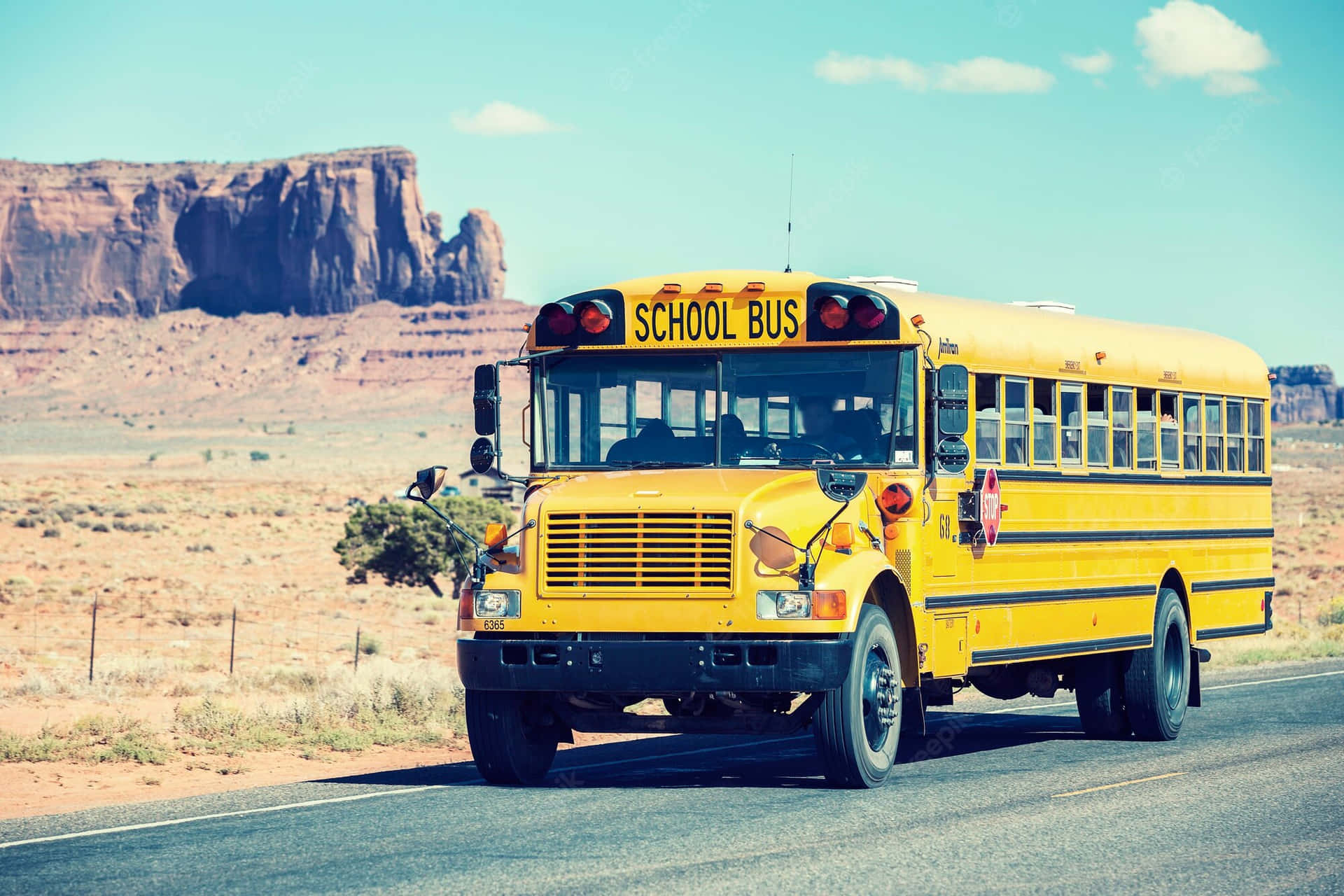 School Bus Traveling Near Monument Valley Background