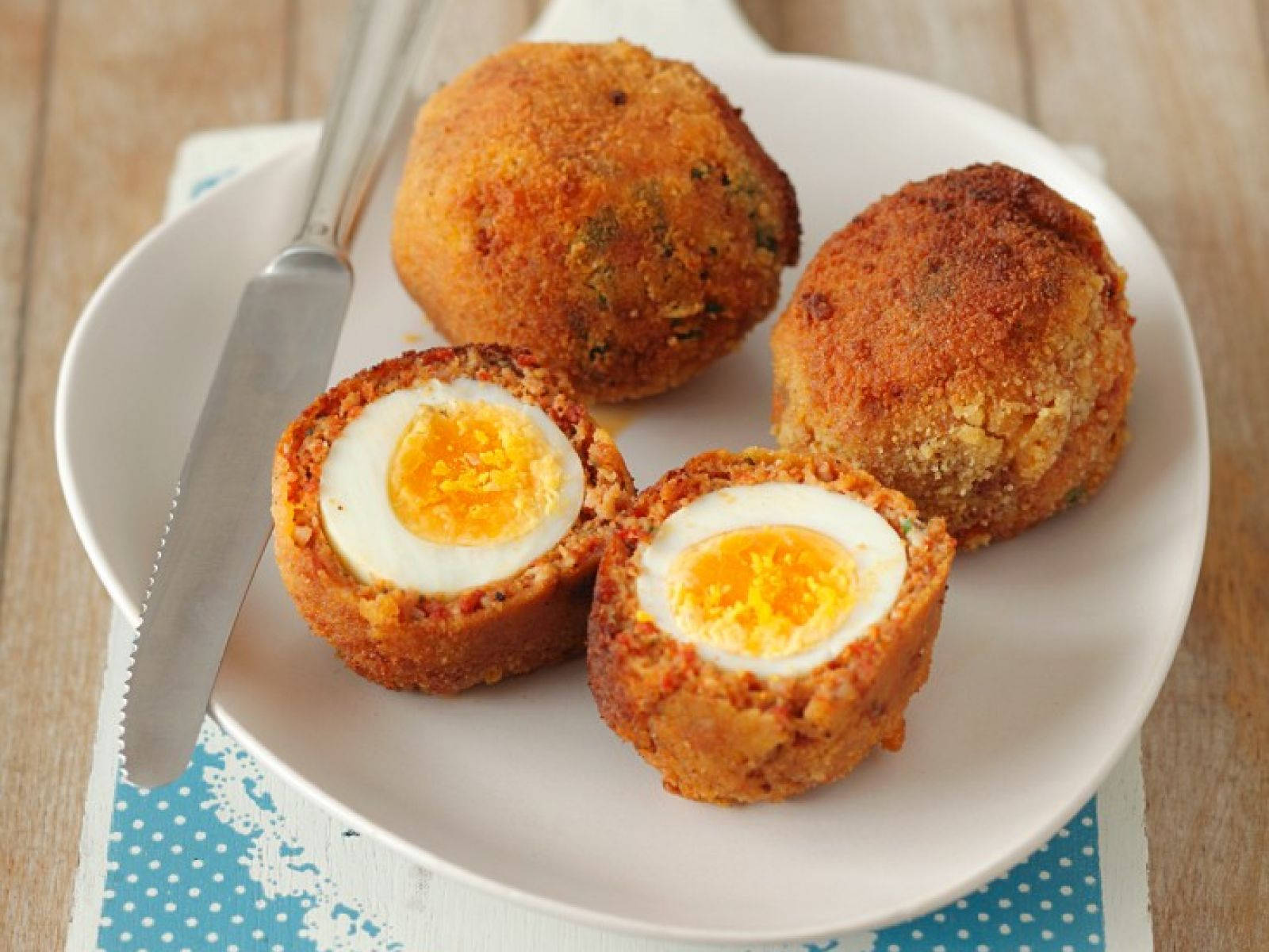 Scotch Eggs And Dinner Knife On A Plate Background