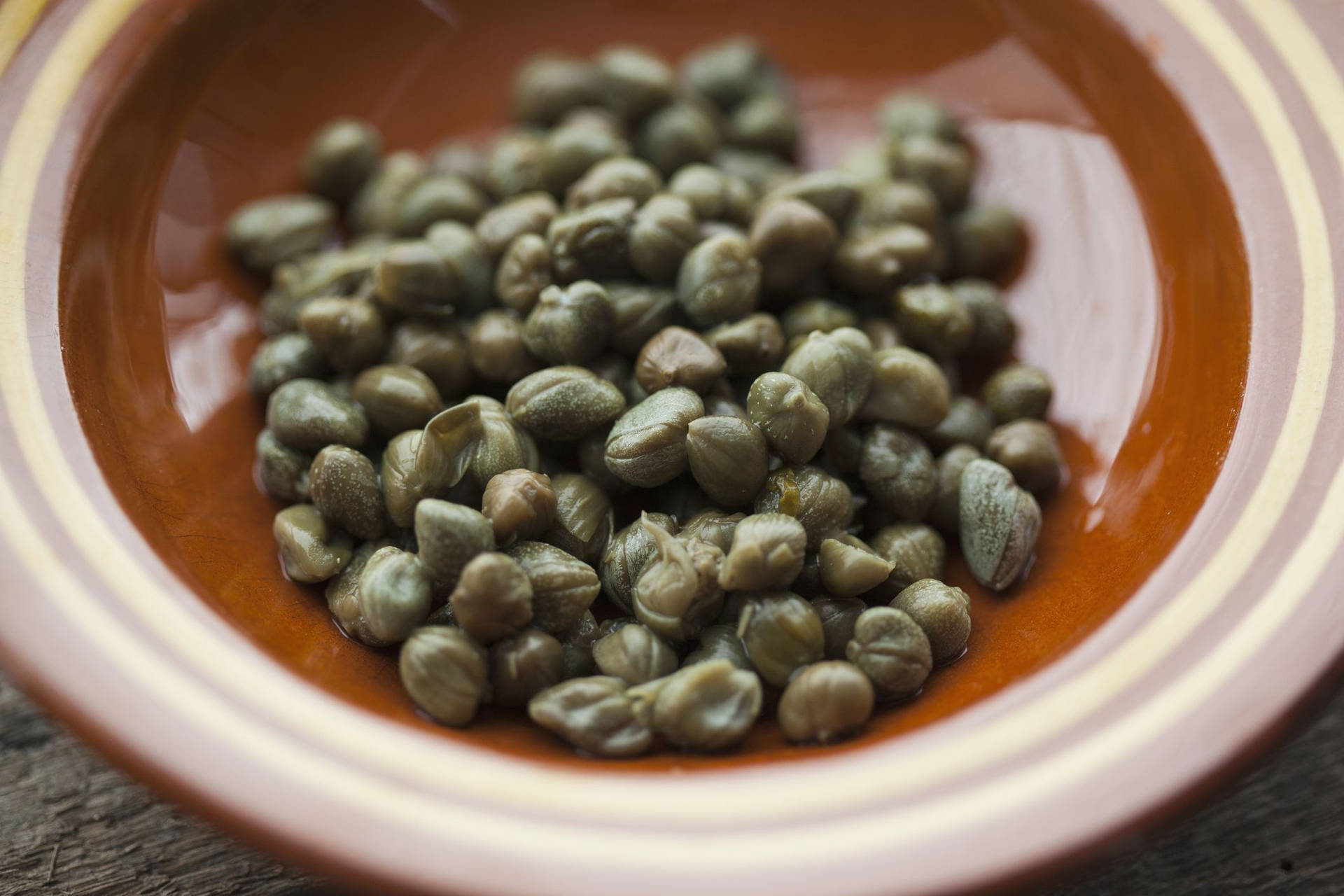 Scrumptious Dried Capers In A Rustic Brown Plate Background