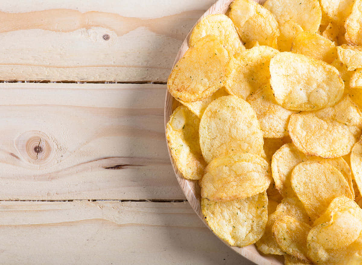 Scrumptious Flat Chips Spilled On The Rustic Wooden Table Background