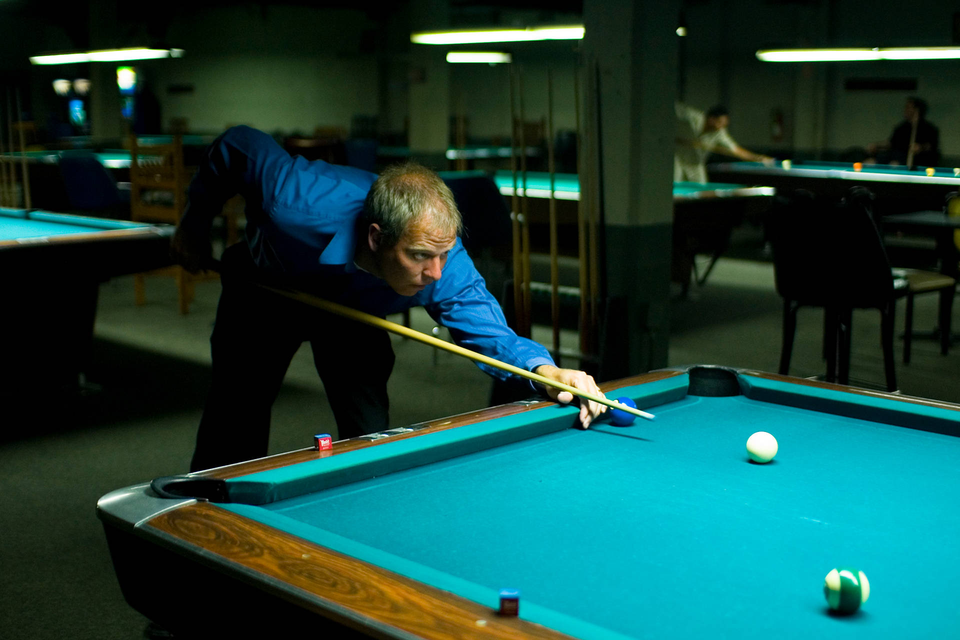 Seasoned Professional Showcasing His Skills In Billiards Background