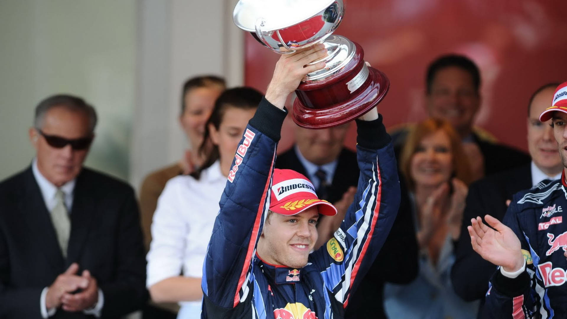 Sebastian Vettel Holding Up A Trophy Background