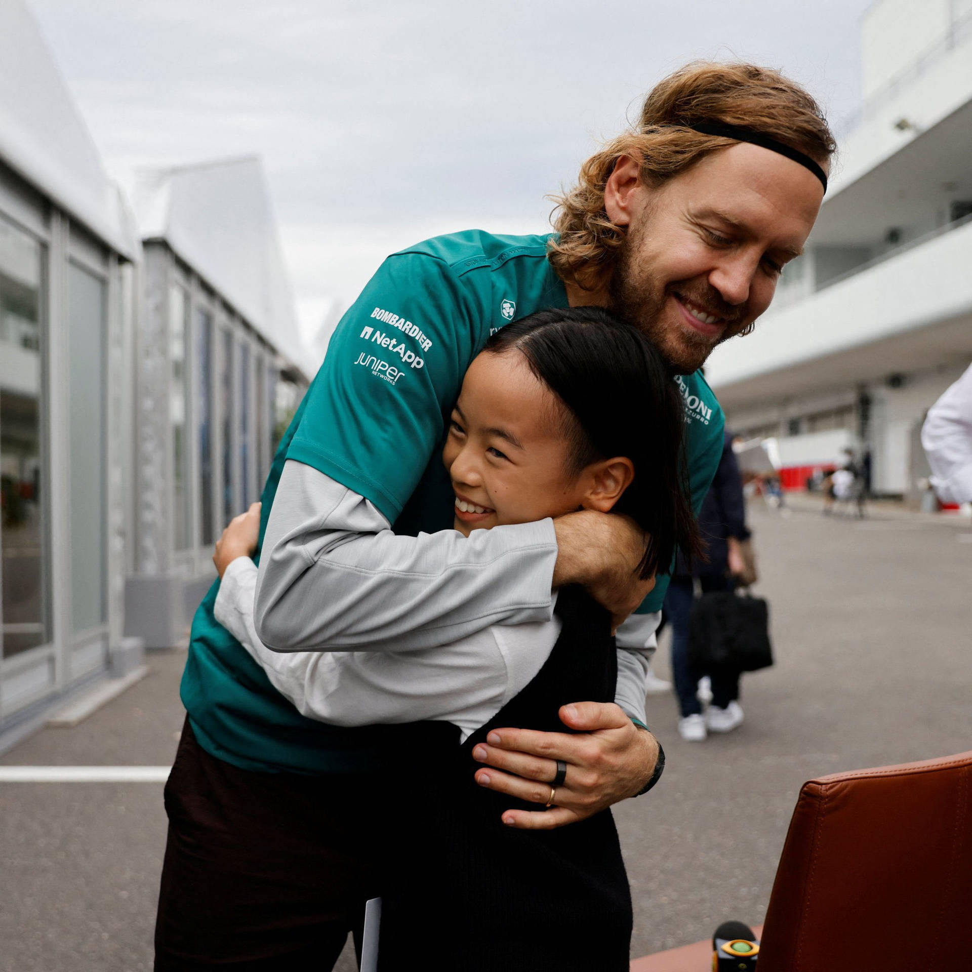 Sebastian Vettel Hugging A Girl Background