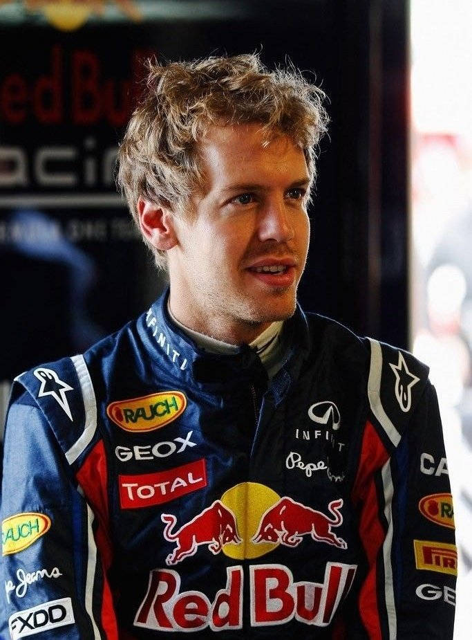 Sebastian Vettel In Intense Racing Suit Background