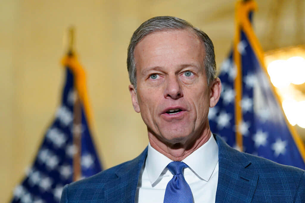 Senator John Thune In Blue Suit And Tie Background