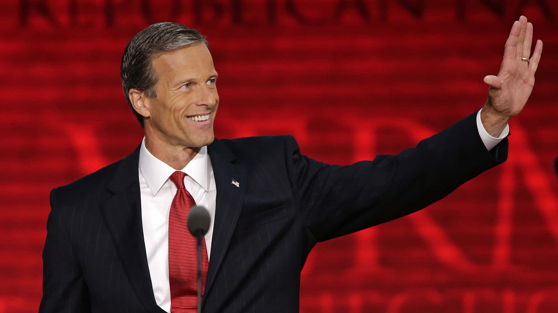 Senator John Thune Posed Against A Red Background Background
