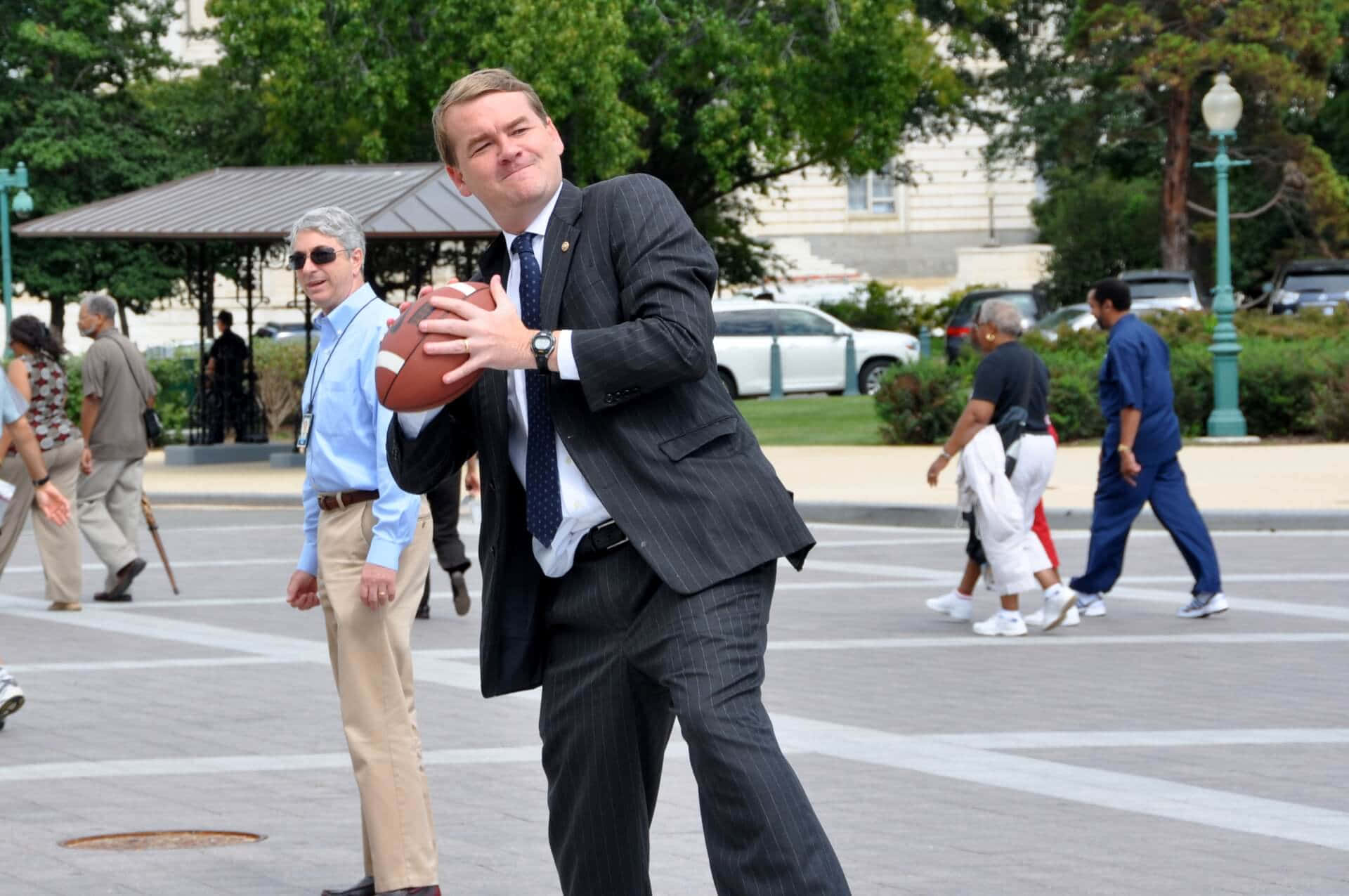 Senator Michael Bennet Making A Basketball Shot Background