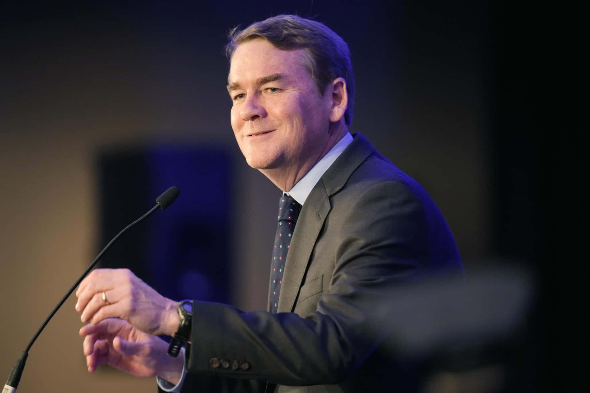Senator Michael Bennet Speaks At A Public Event Background