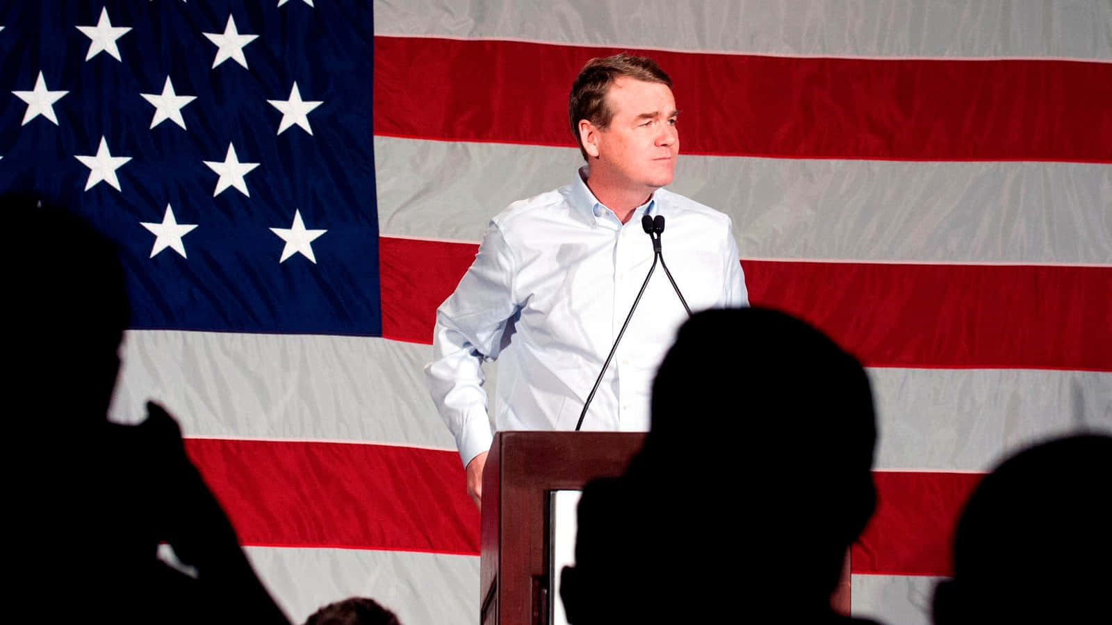 Senator Michael Bennet Stands With An American Flag Background