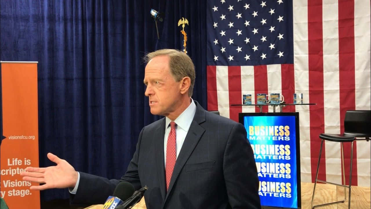 Senator Pat Toomey Speaking At A Business Event Background