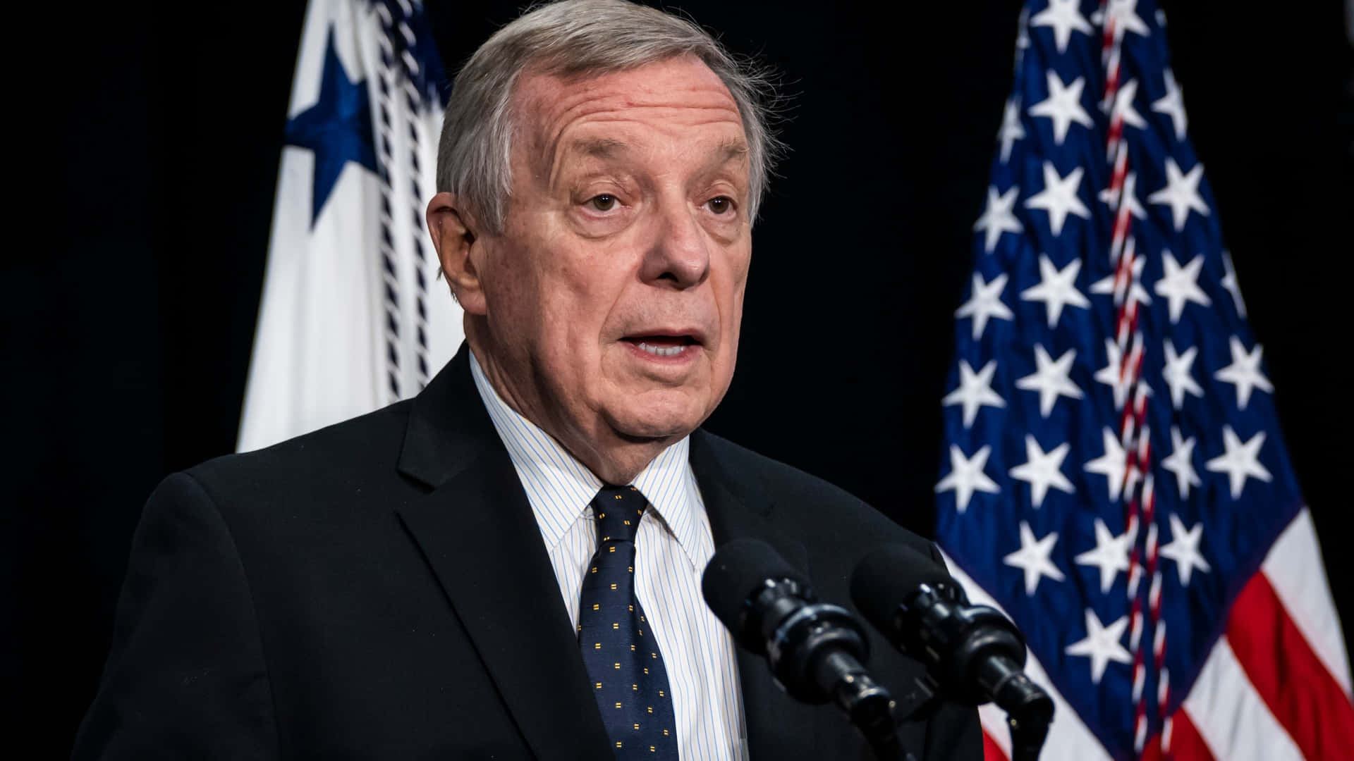 Senator Richard Durbin In Front Of American Flags Background