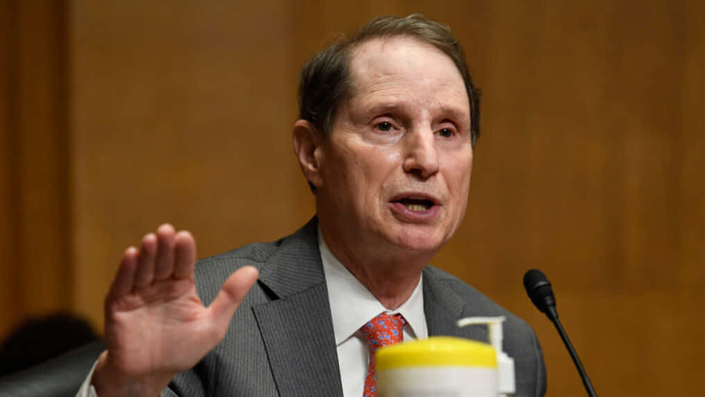 Senator Ron Wyden Speaking Into A Microphone Background