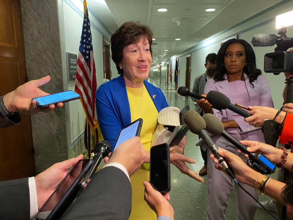 Senator Susan Collins Engaged In A Press Briefing Background