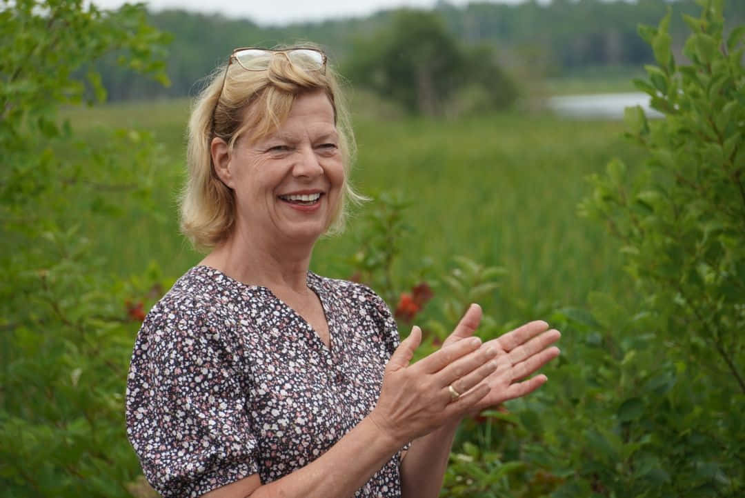 Senator Tammy Baldwin Applauding With A Smile Background