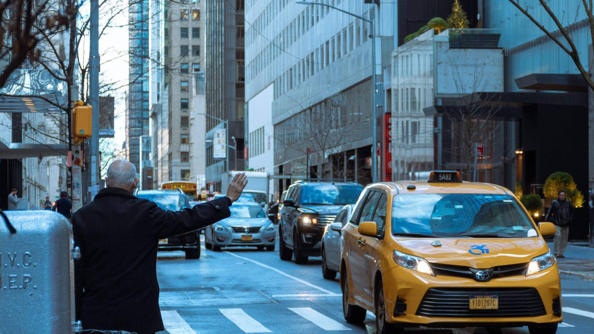 Senior Man Signaling Taxi In City Background