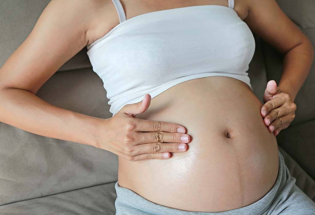 Serene Mother-to-be Cradling Her Growing Belly Background