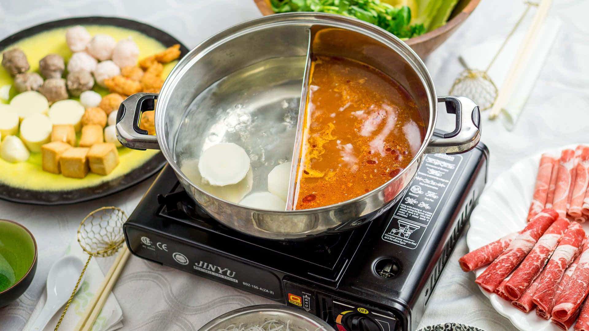 Shabu-shabu In Dual Pot On A Stove Background