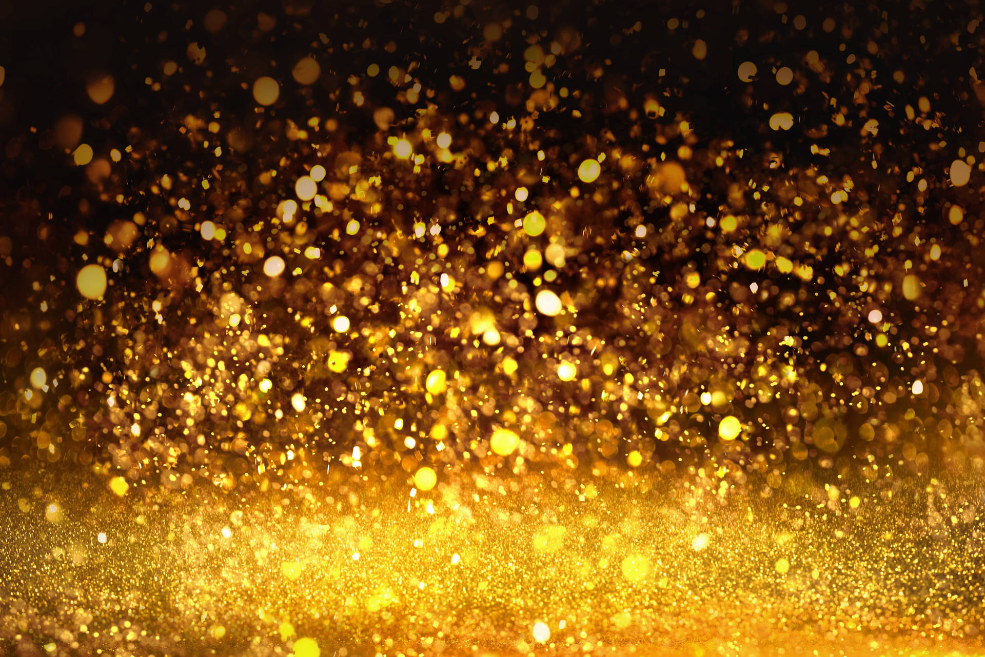 Shimmering Golden Glitters On A Dark Background