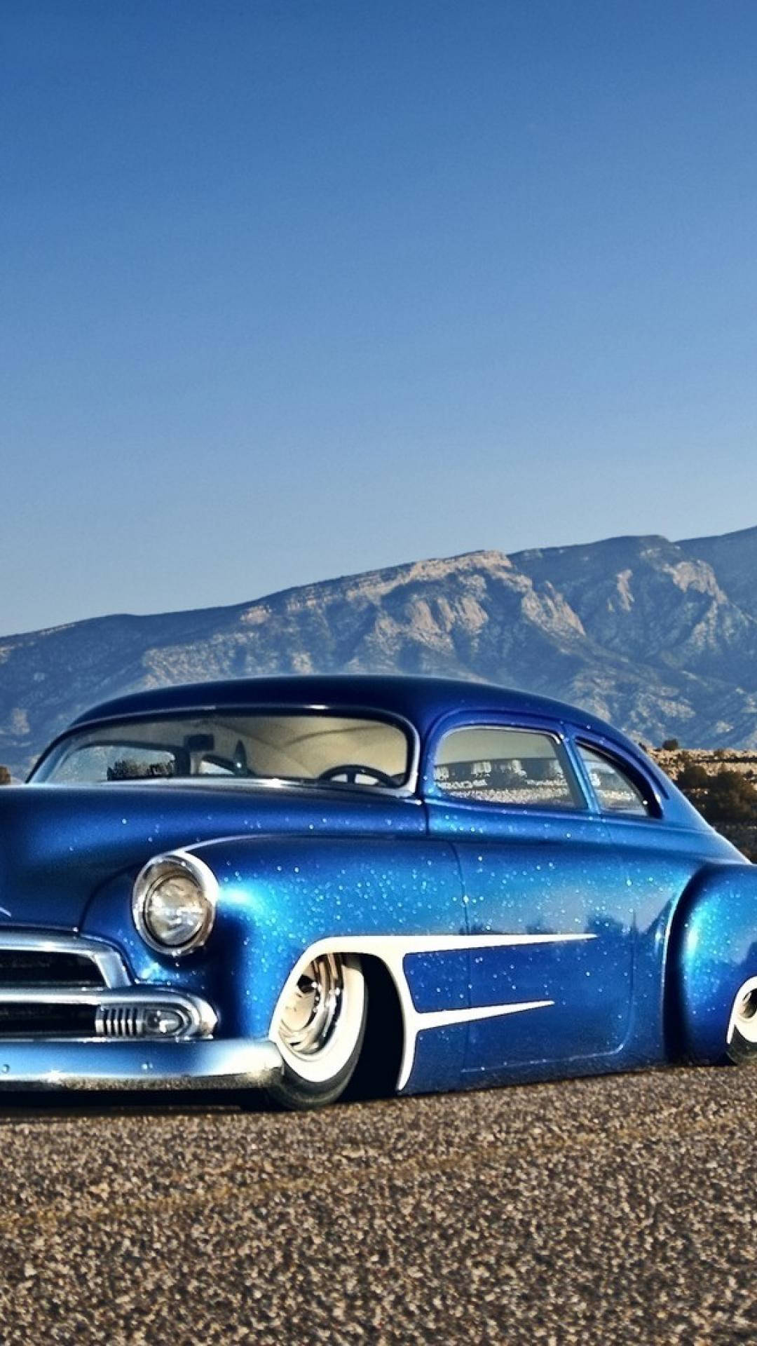 Shiny Blue Car Mountains Phone Background