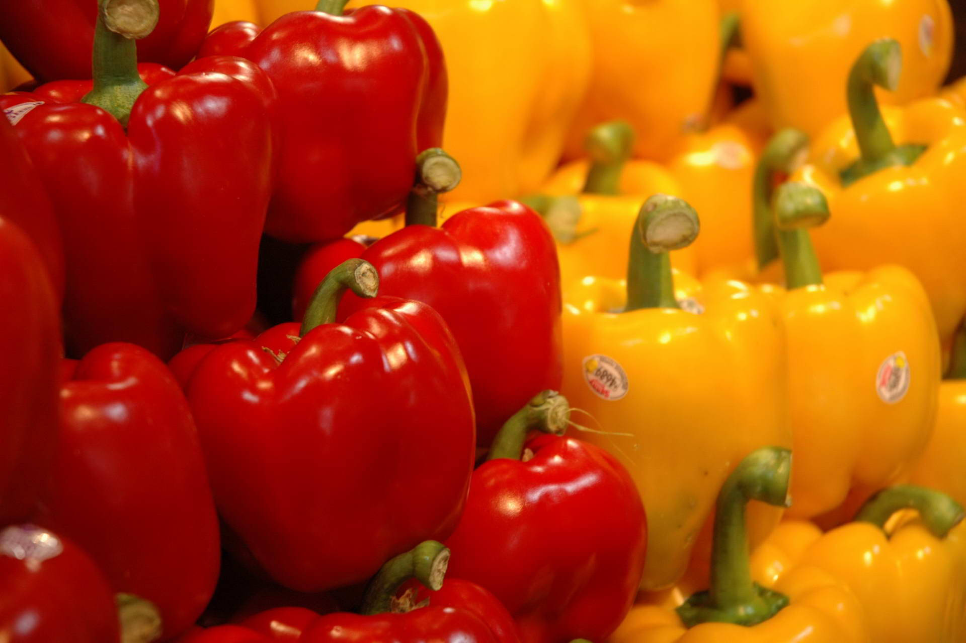 Shiny Red And Yellow Bell Pepper Fruits Pile Background