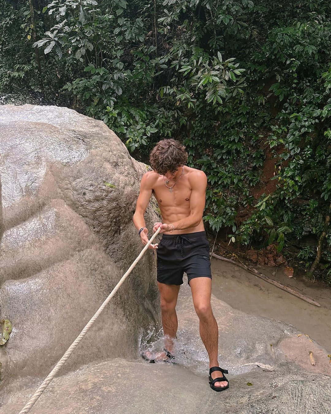 Shirtless Man Climbing Rock With Rope