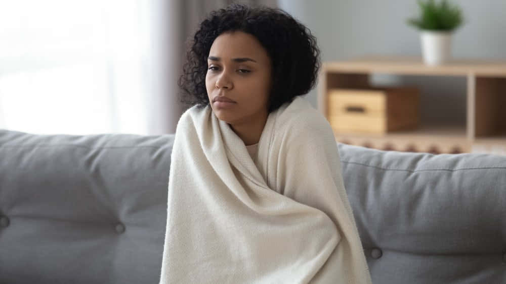 Shivering Woman Holding Blanket [wallpaper] Background