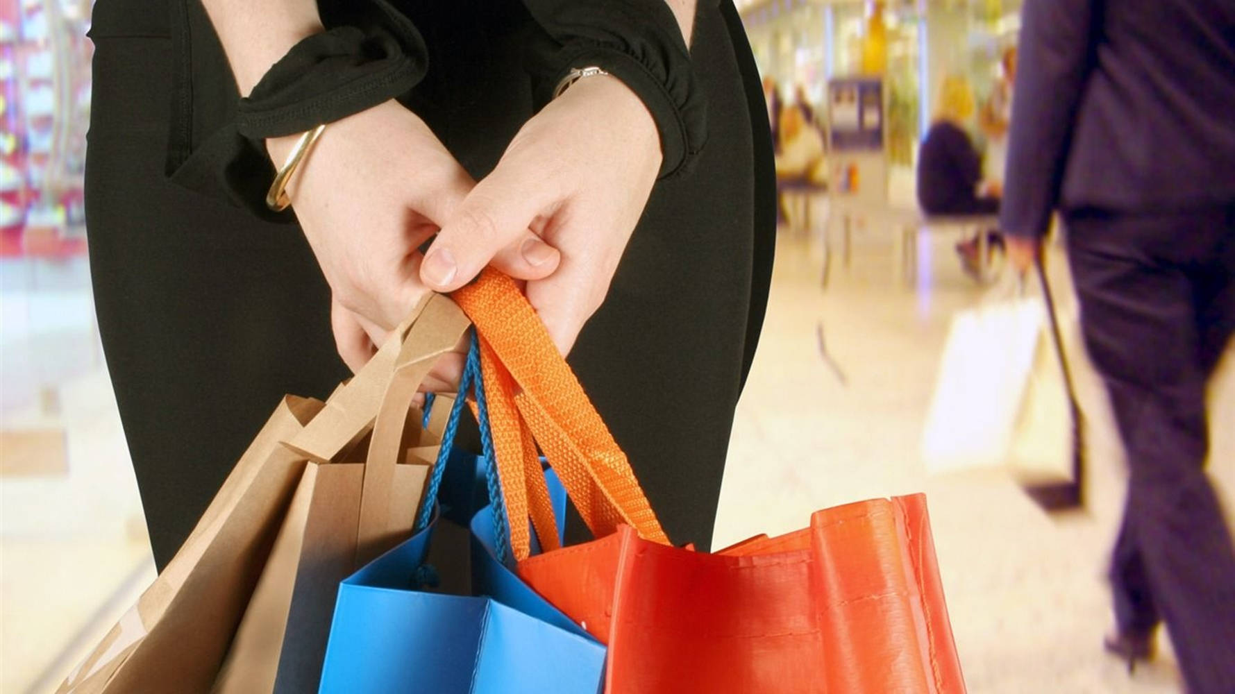Shopper Carrying Multiple Colored Shopping Bags Background