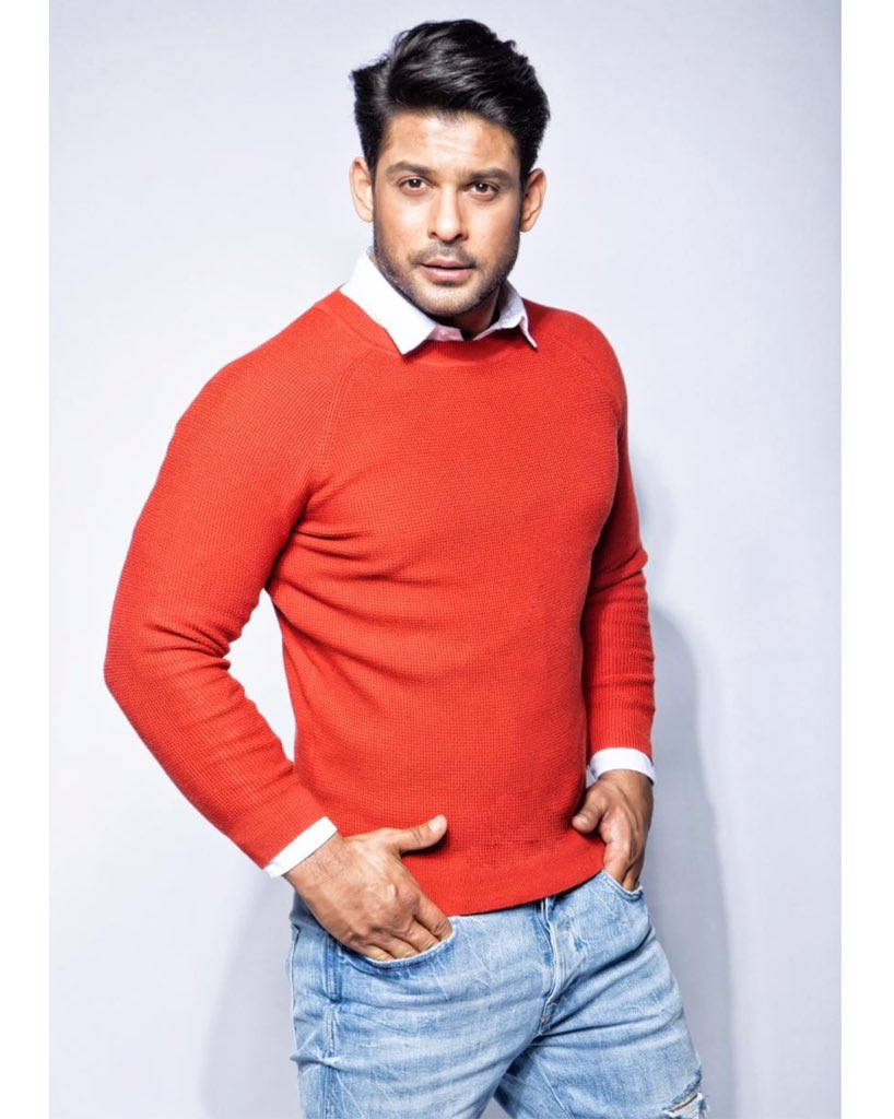 Sidharth Shukla In Red Sweater Standing Sideways Background