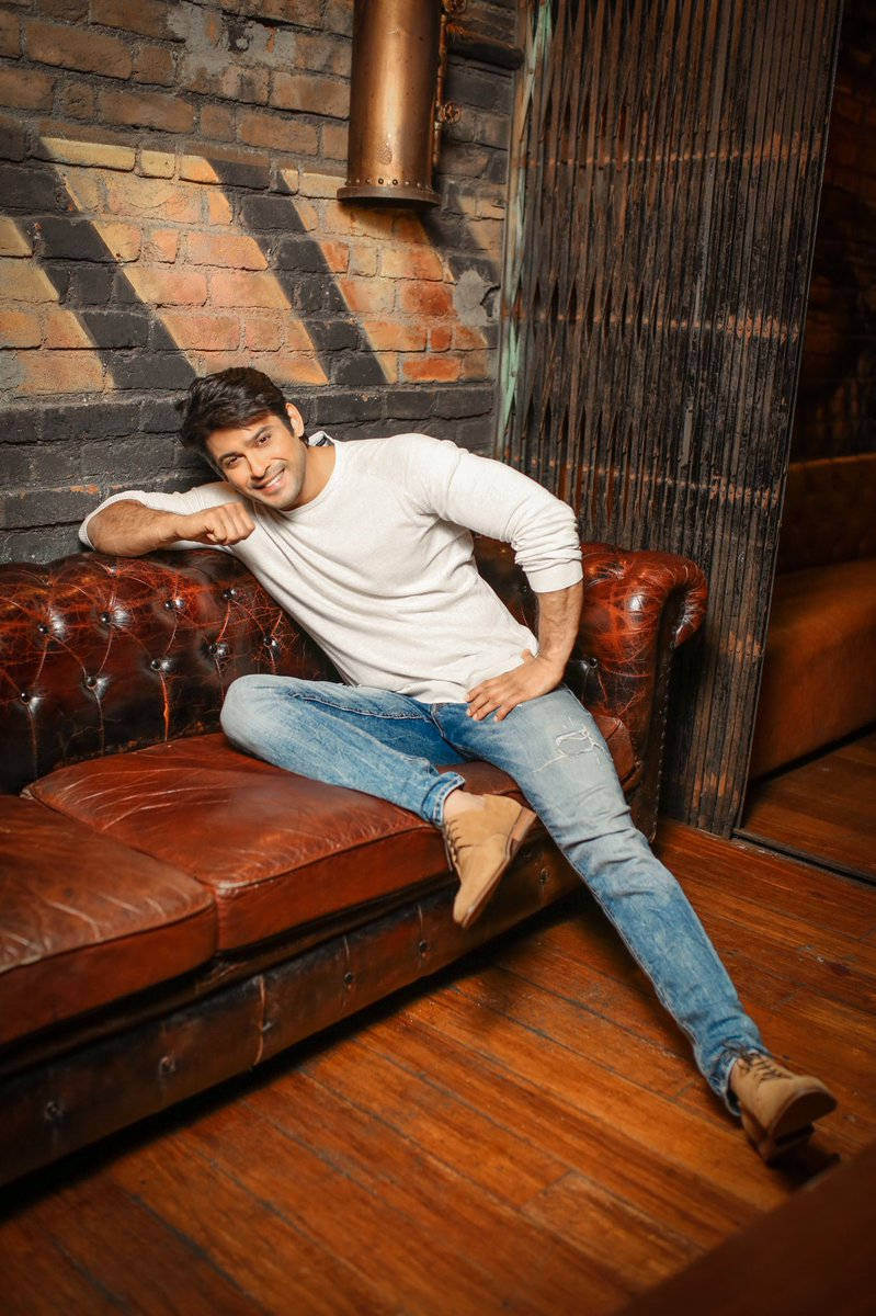 Sidharth Shukla Sitting On A Chesterfield Sofa Background