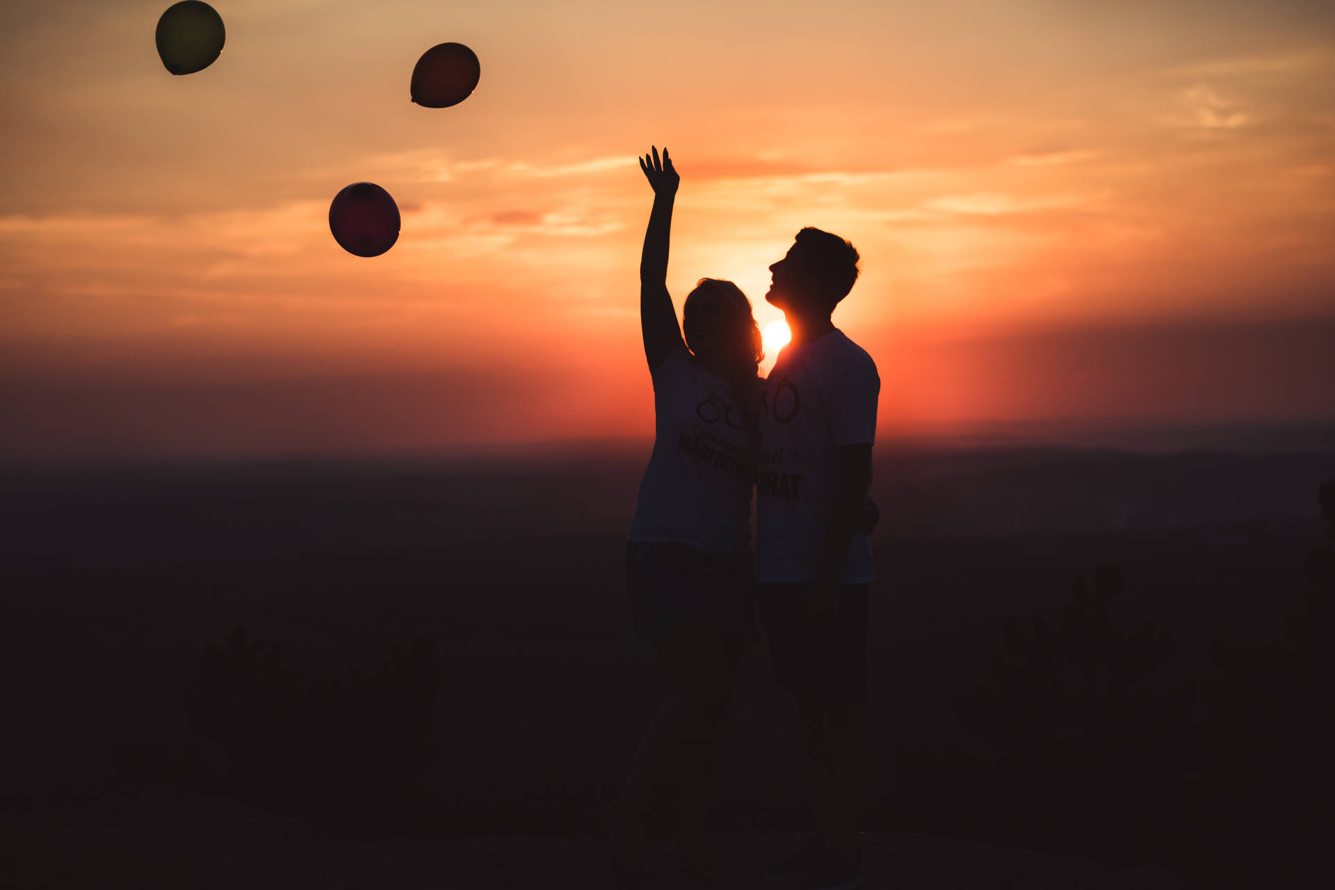 Silhouette Couple Releasing Balloons Background