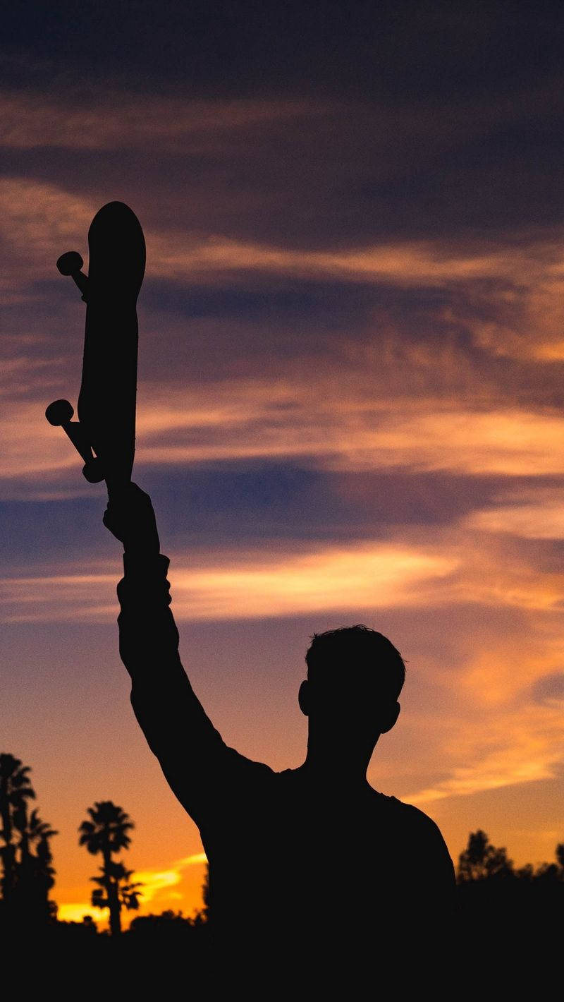 Silhouette Of Man Holding Skateboard Iphone Background