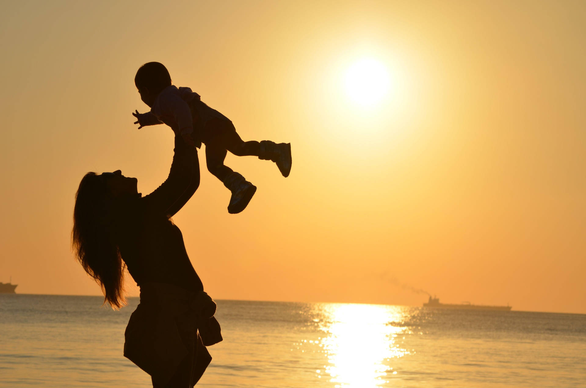 Silhouette Of Mother In Beach Background