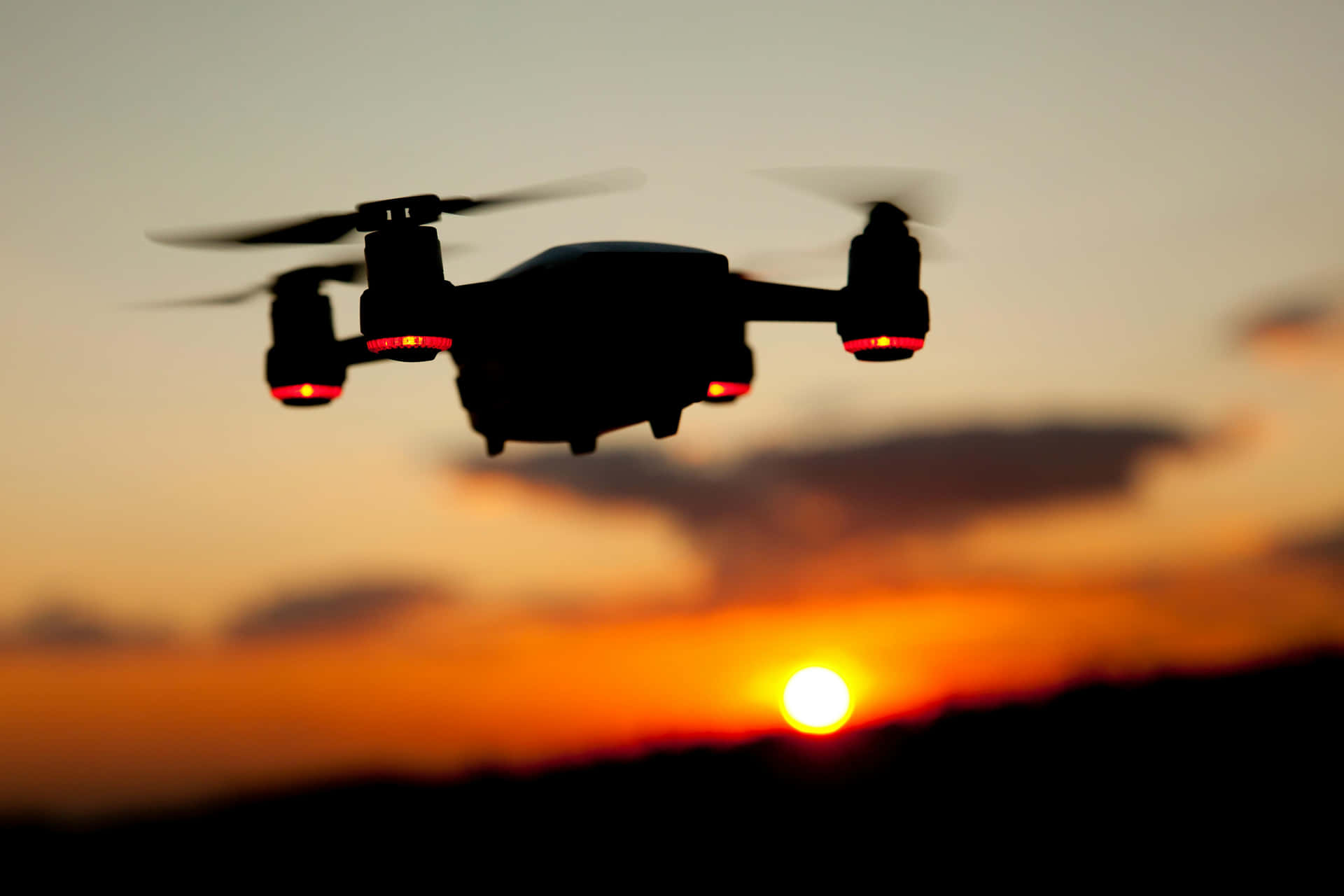 Silhouetted Drone Against Sunset Sky Background