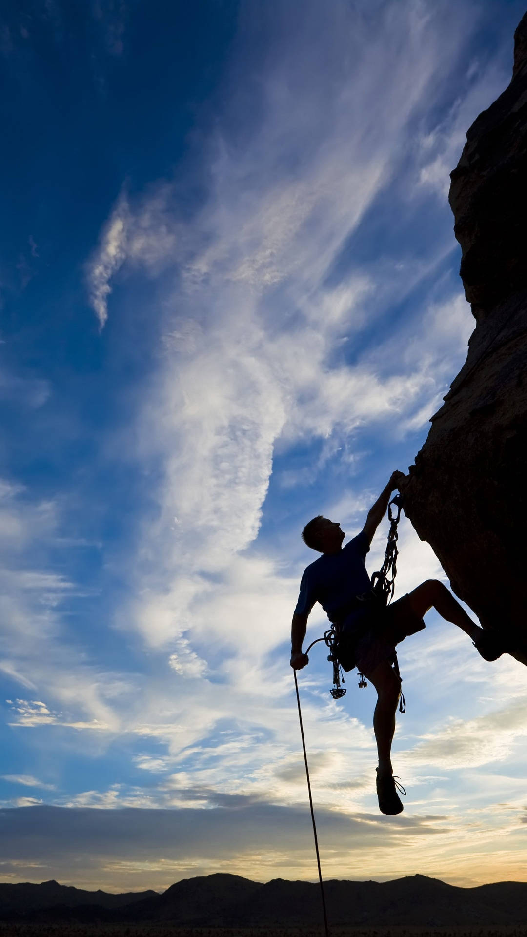 Silhouetted Man Climbing A Rock Background