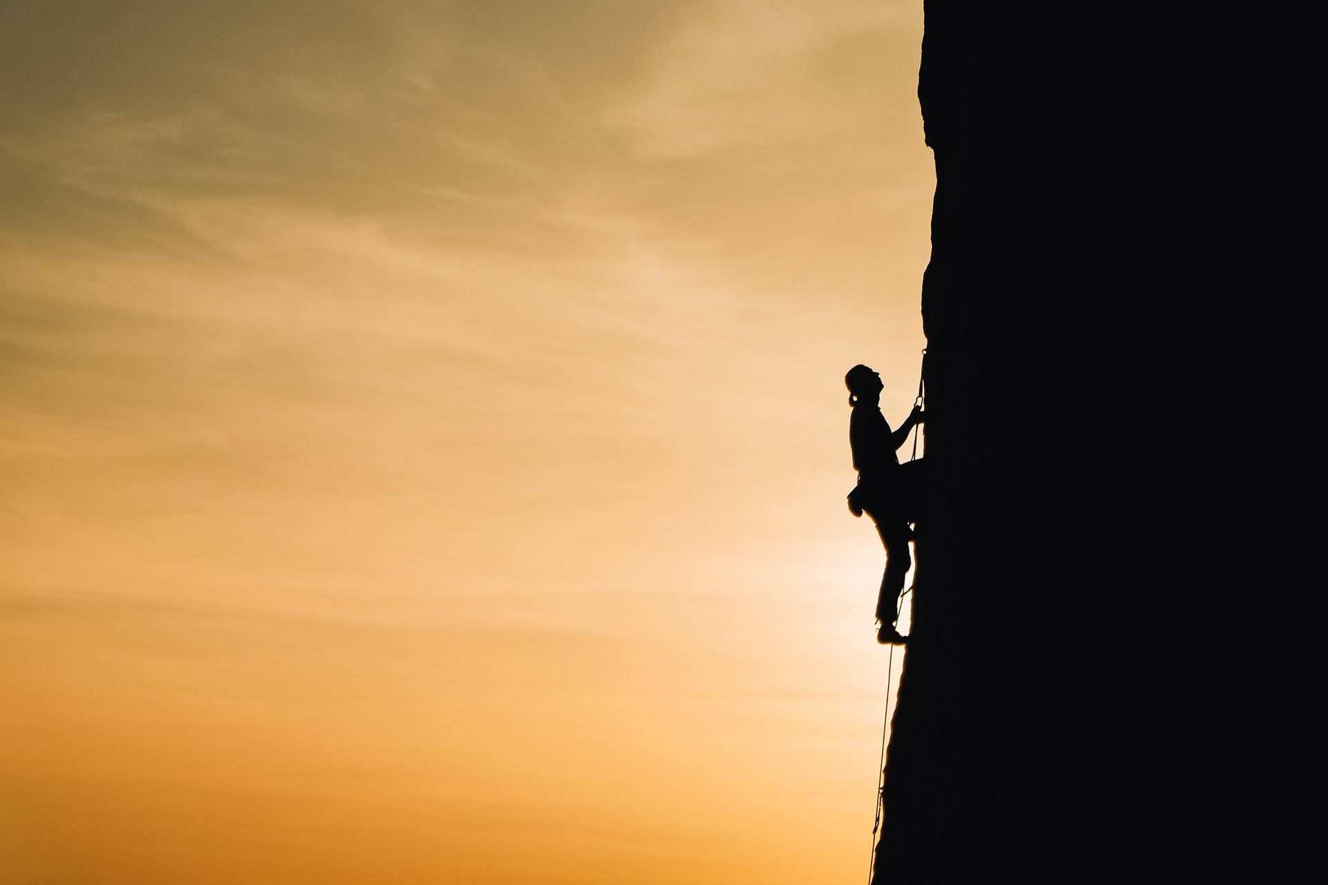 Silhouetted Man Rock Climbing