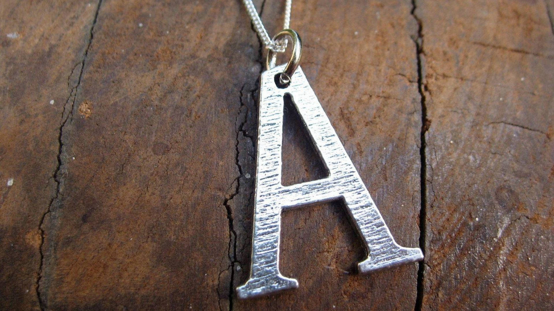 Silver A Alphabet In Wood Background