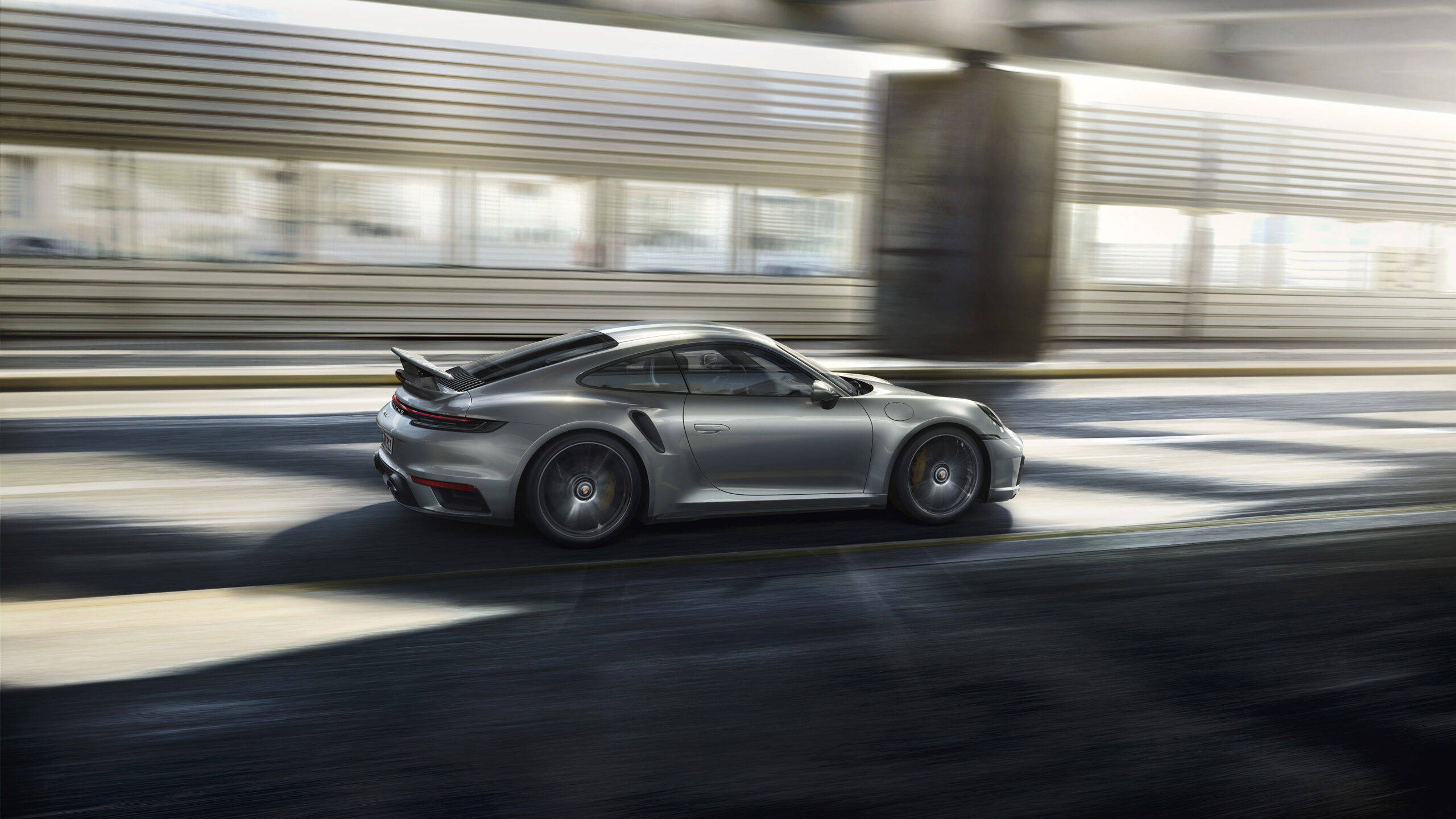 Silver Porsche 911 Driving Beside Building