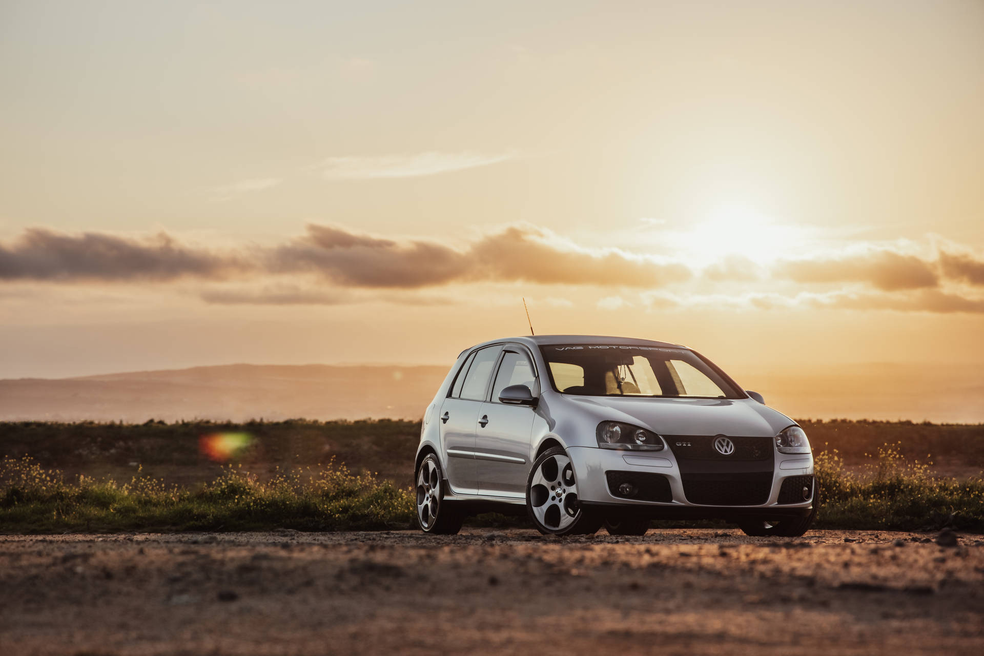 Silver Volkswagen Golf Gti In Sunset Background