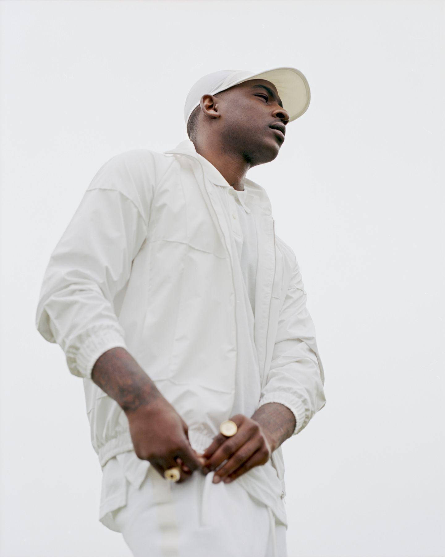 Skepta On Full White Outfit Background