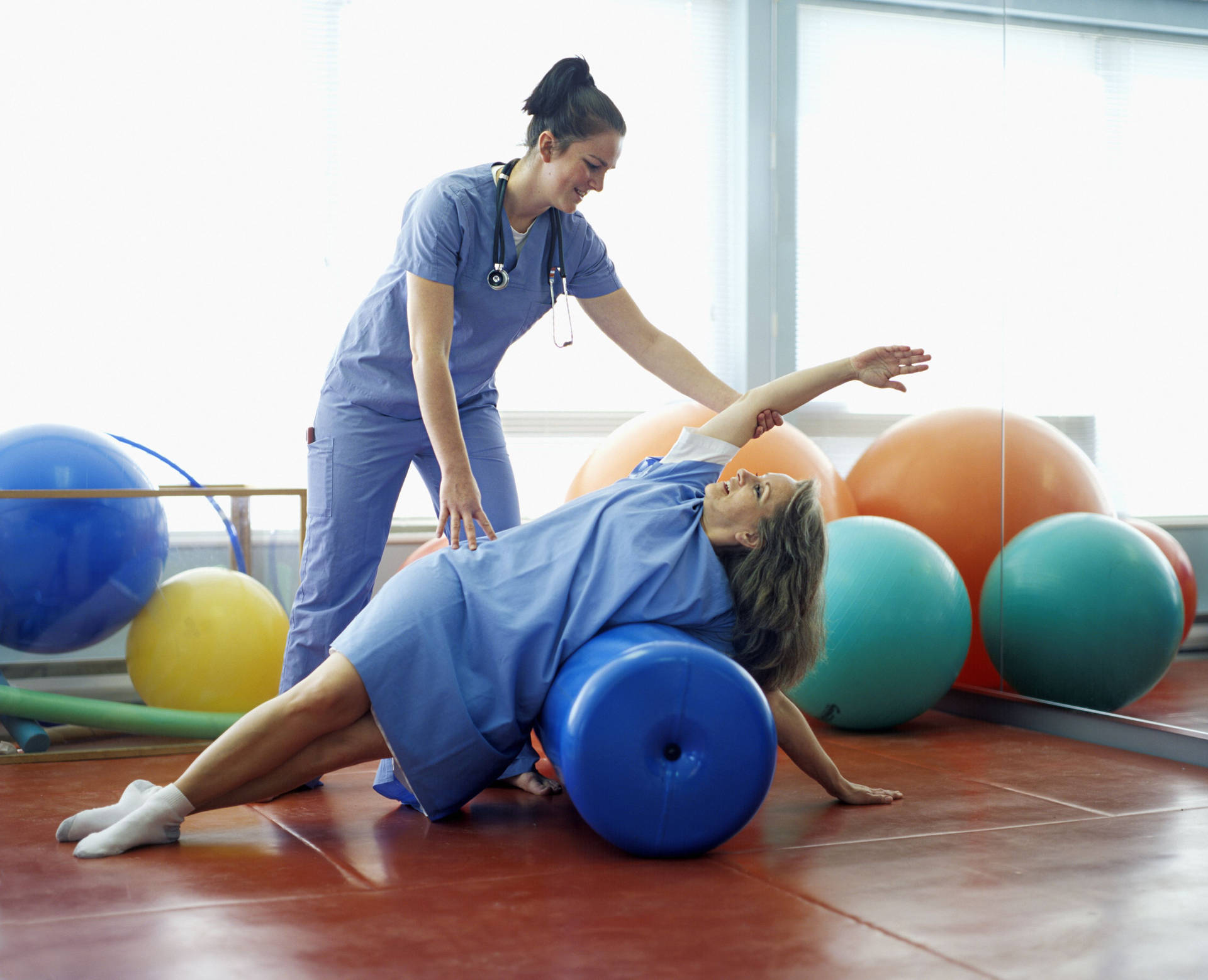 Skilled Therapist Guiding Patient In Physical Therapy Background