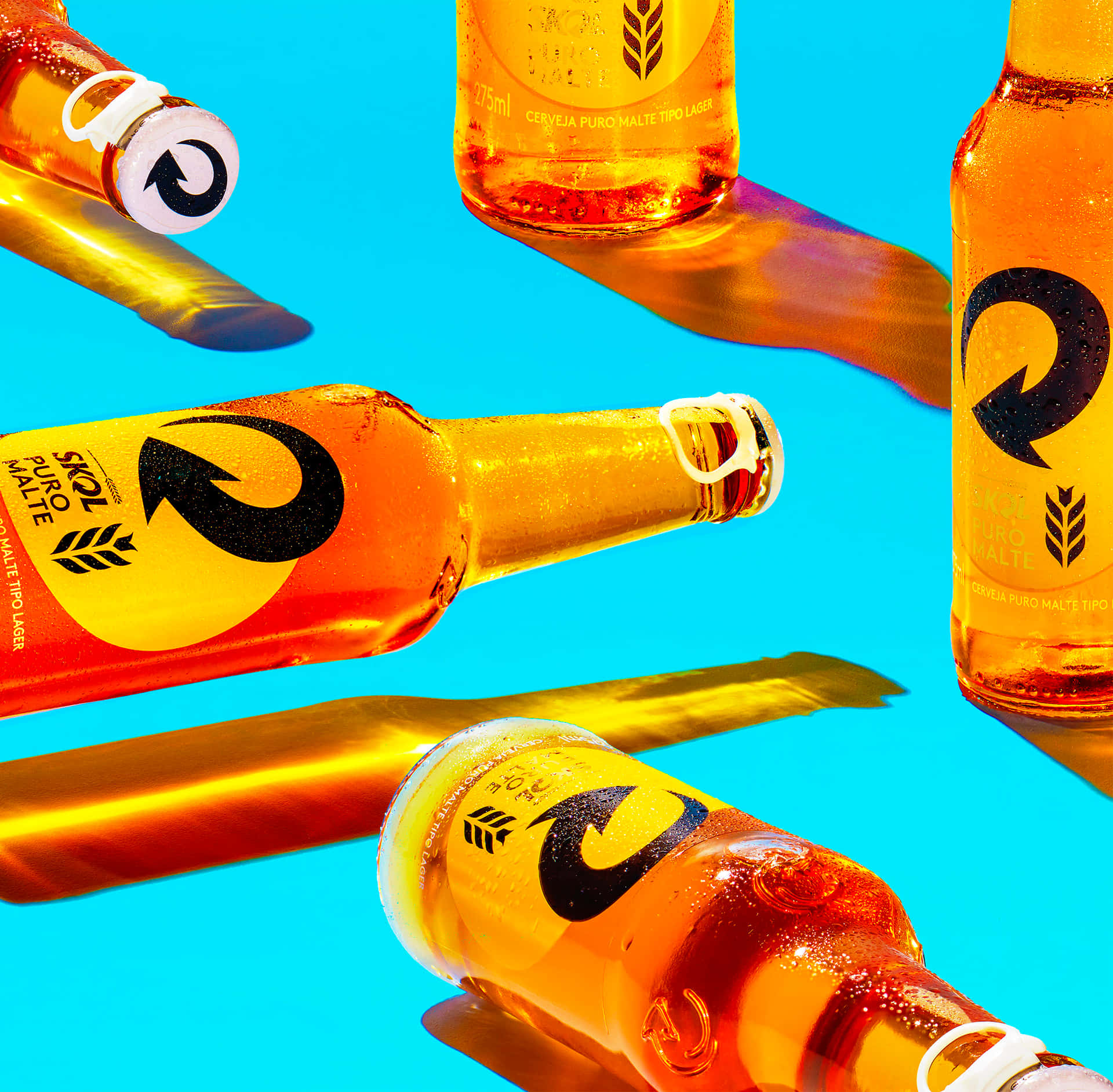 Skol Beer Bottles Floating Against Blue Background Background
