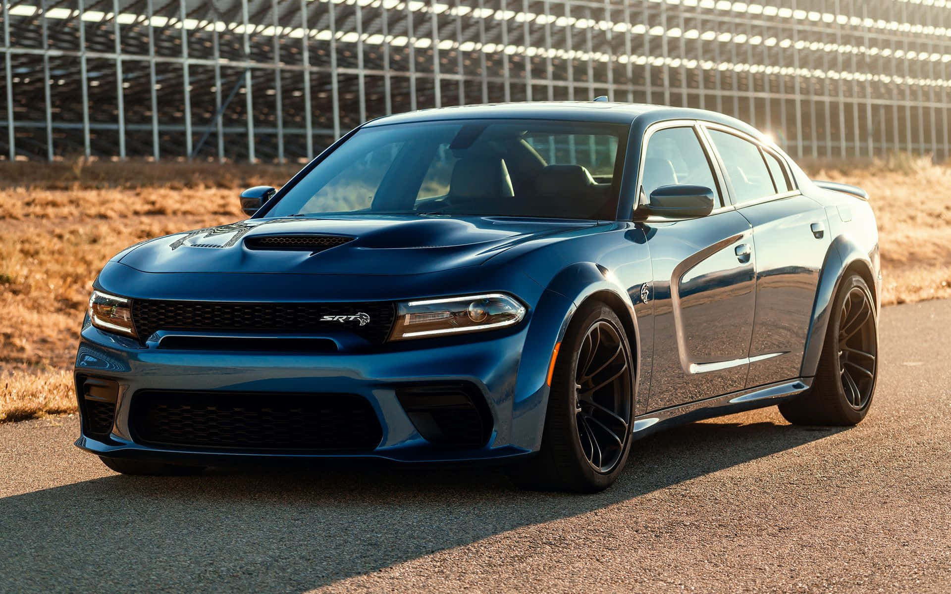 Sleek And Powerful Dodge Charger On The Open Road Background