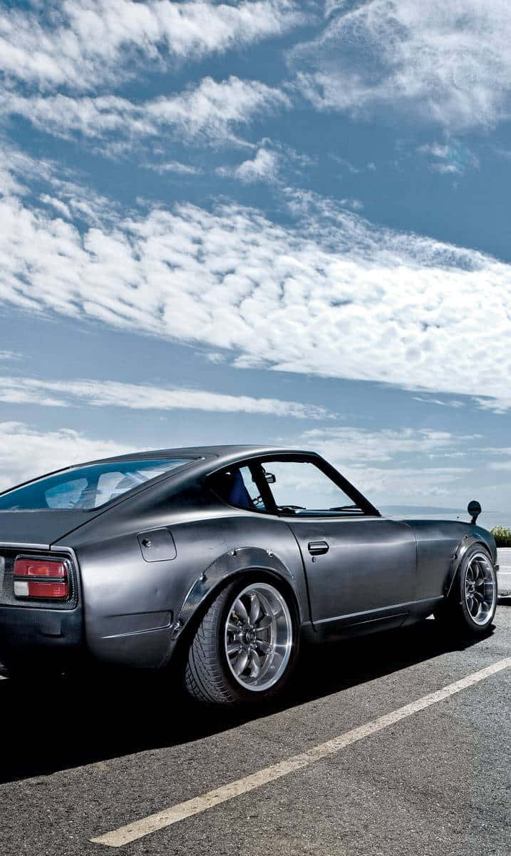 Sleek And Stylish Datsun Car On The Road Background
