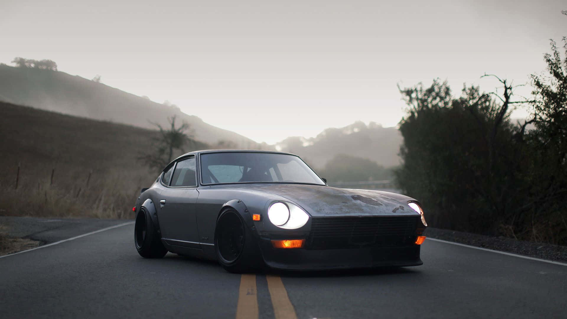 Sleek And Stylish Datsun On The Road Background