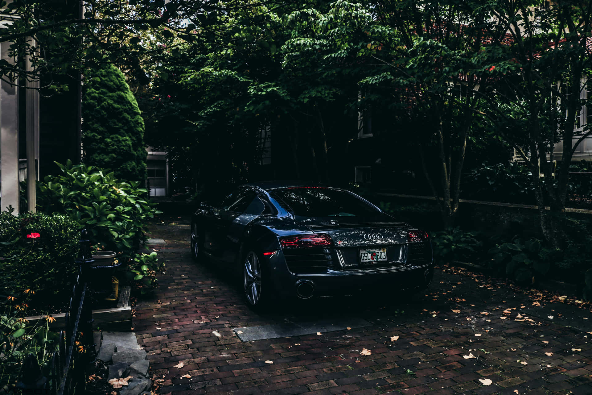Sleek Black Car Brick Driveway