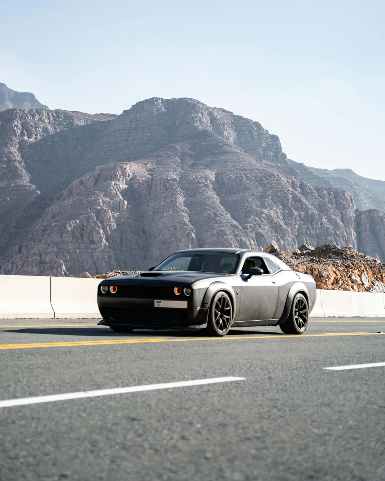Sleek Black Car Mountain Road Background