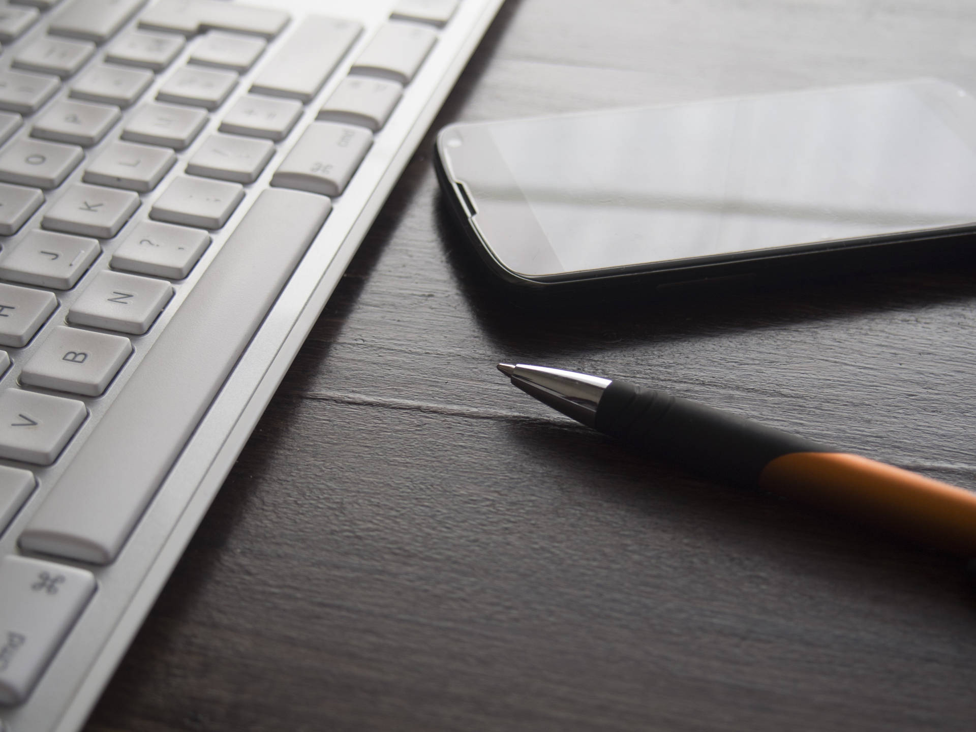 Sleek Computer Keyboard On A Desk Background