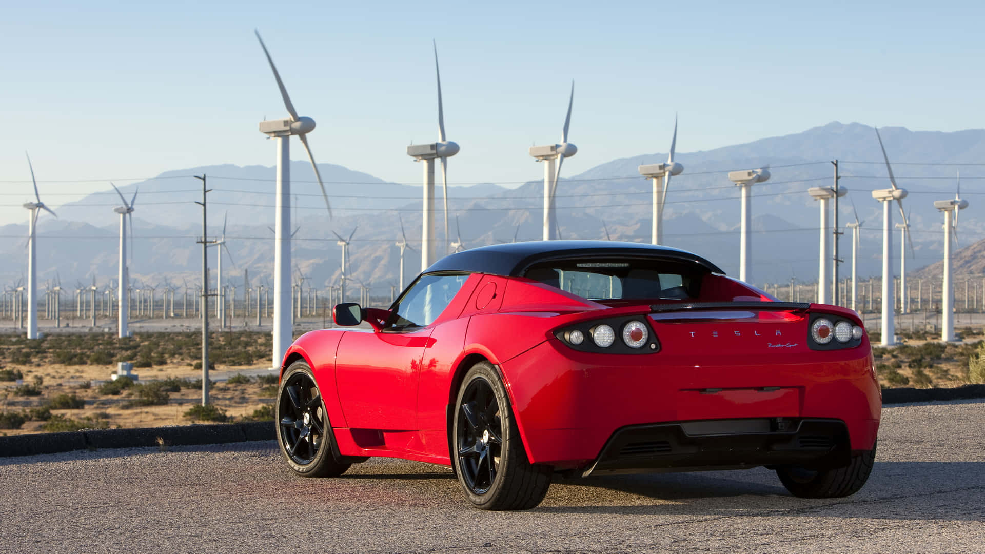 Sleek, Powerful Tesla Roadster Against Night Sky Background