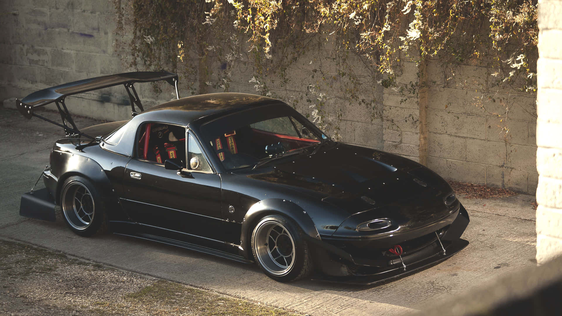 Sleek Red Miata Under Blue Sky Background