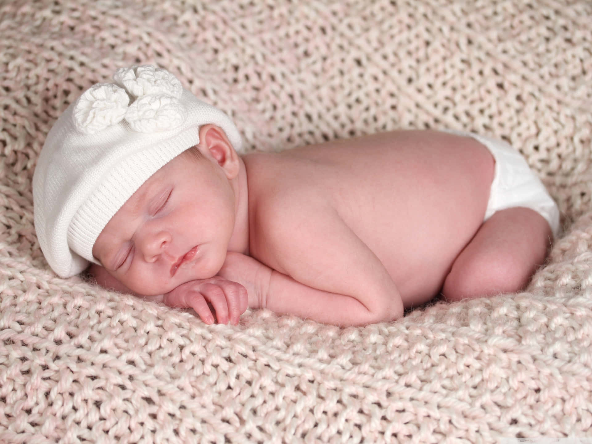 Sleeping New Born Baby With A White Cap Background
